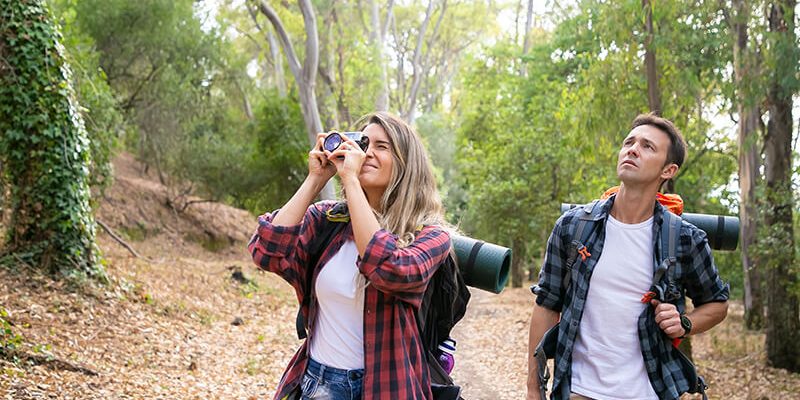 pretty-woman-taking-photo-landscape-with-camera-traveling-with-boyfriend-caucasian-tourists-hiking-together-male-backpacker-looking-scenery-tourism-adventure-summer-vacation-concept